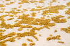 Gold and white distressed texture rug with abstract splatter pattern