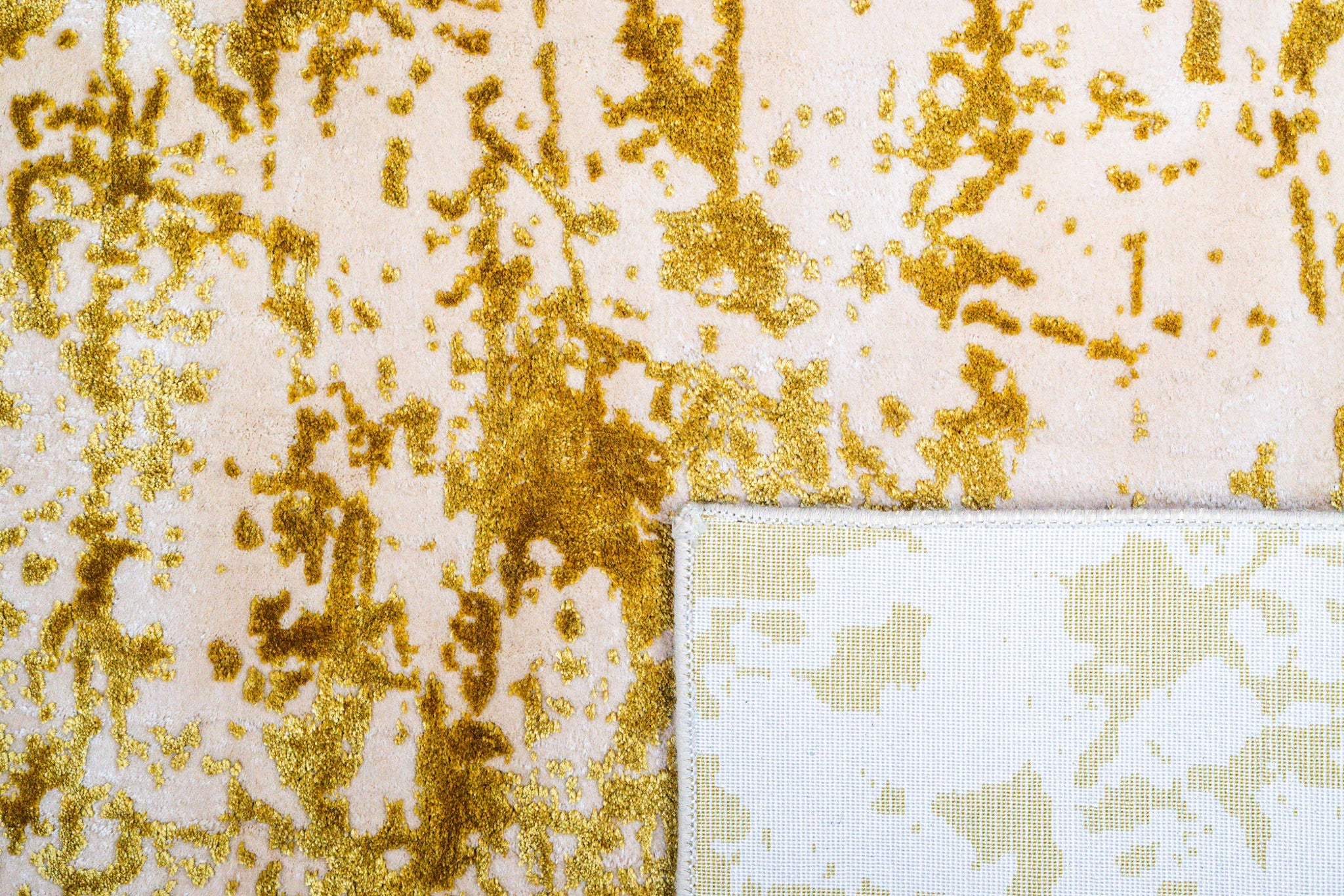 Gold and white distressed texture rug with abstract splatter pattern
