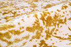 Gold and white distressed texture rug with abstract splatter pattern