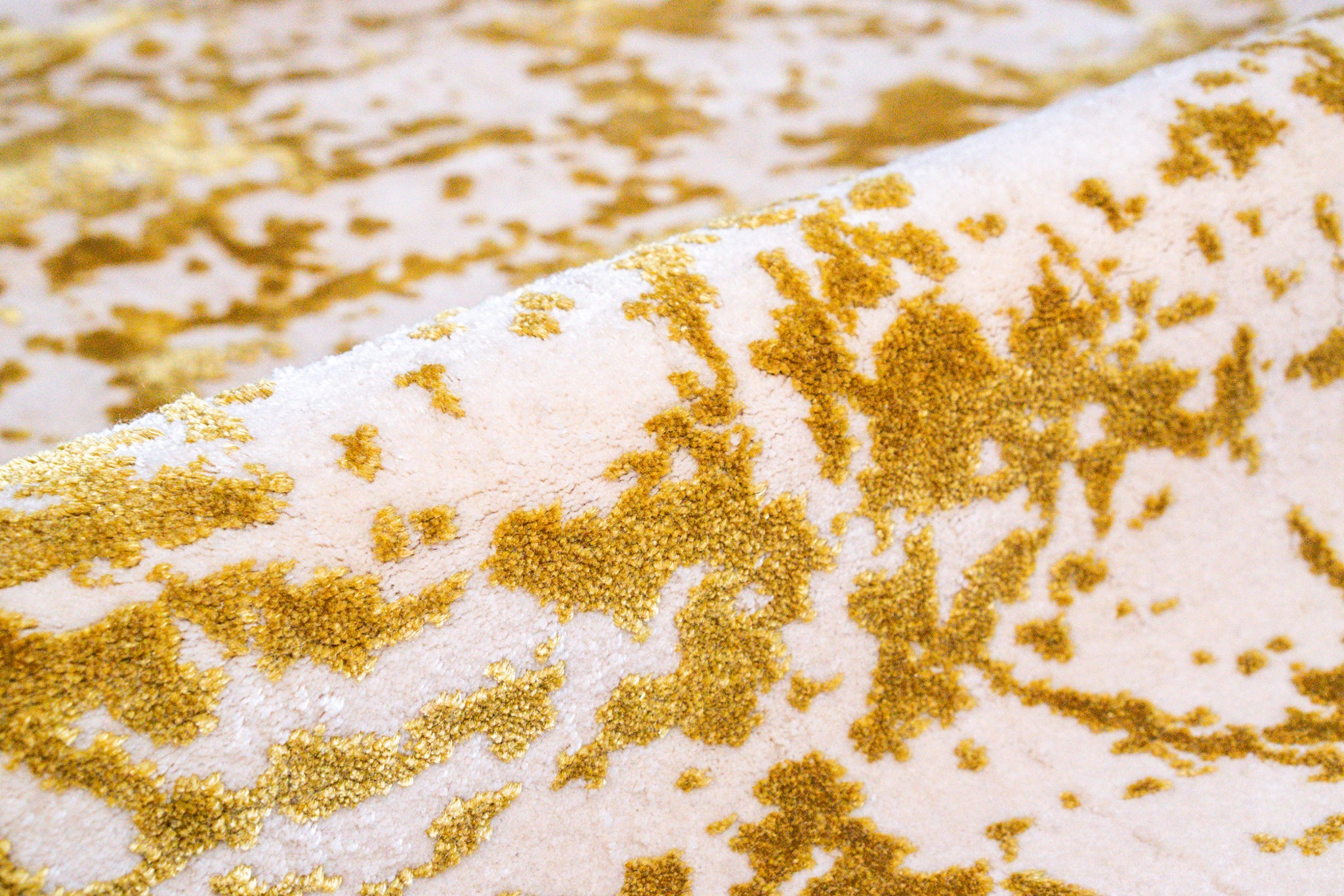 Gold and white distressed texture rug with abstract splatter pattern