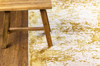 Gold and white distressed texture rug with abstract splatter pattern