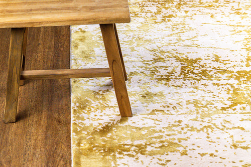 Gold and white distressed texture rug with abstract splatter pattern