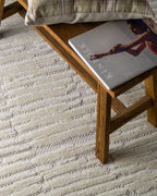 Cream textured rug with geometric brick pattern and subtle tonal details