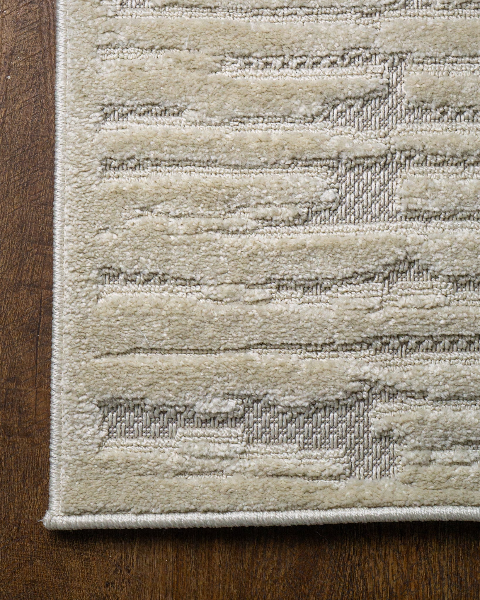 Cream textured rug with geometric brick pattern and subtle tonal details