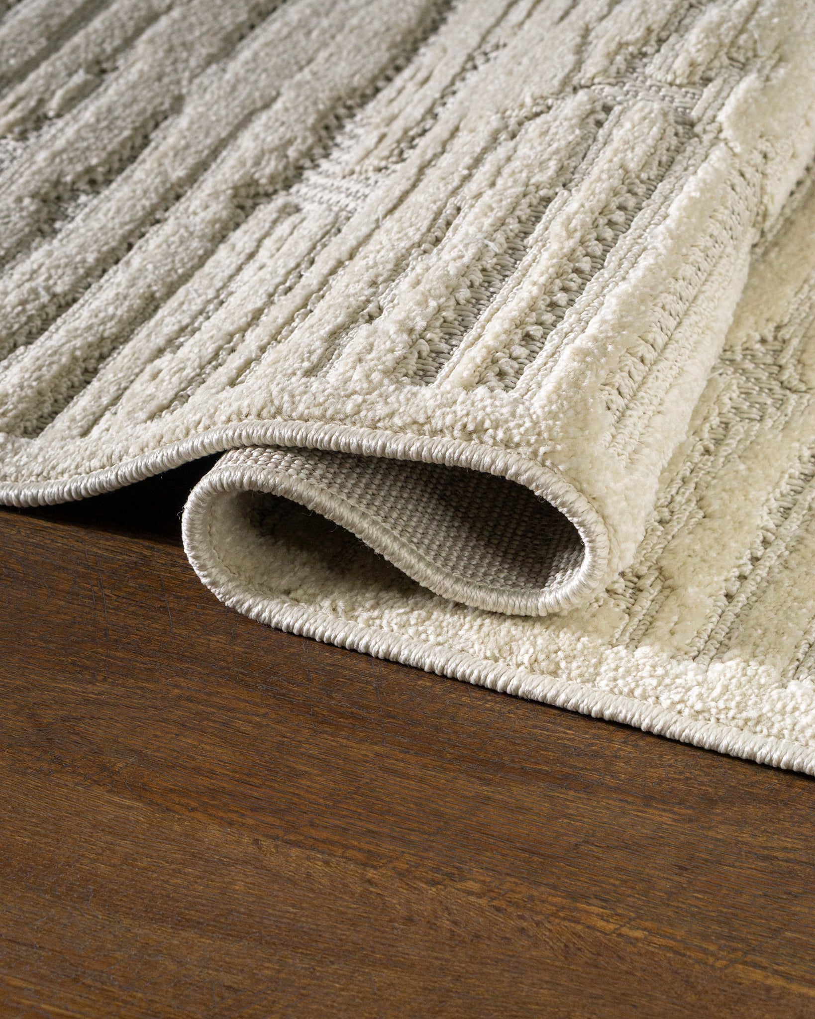 Cream textured rug with geometric brick pattern and subtle tonal details