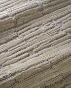Cream textured rug with geometric brick pattern and subtle tonal details