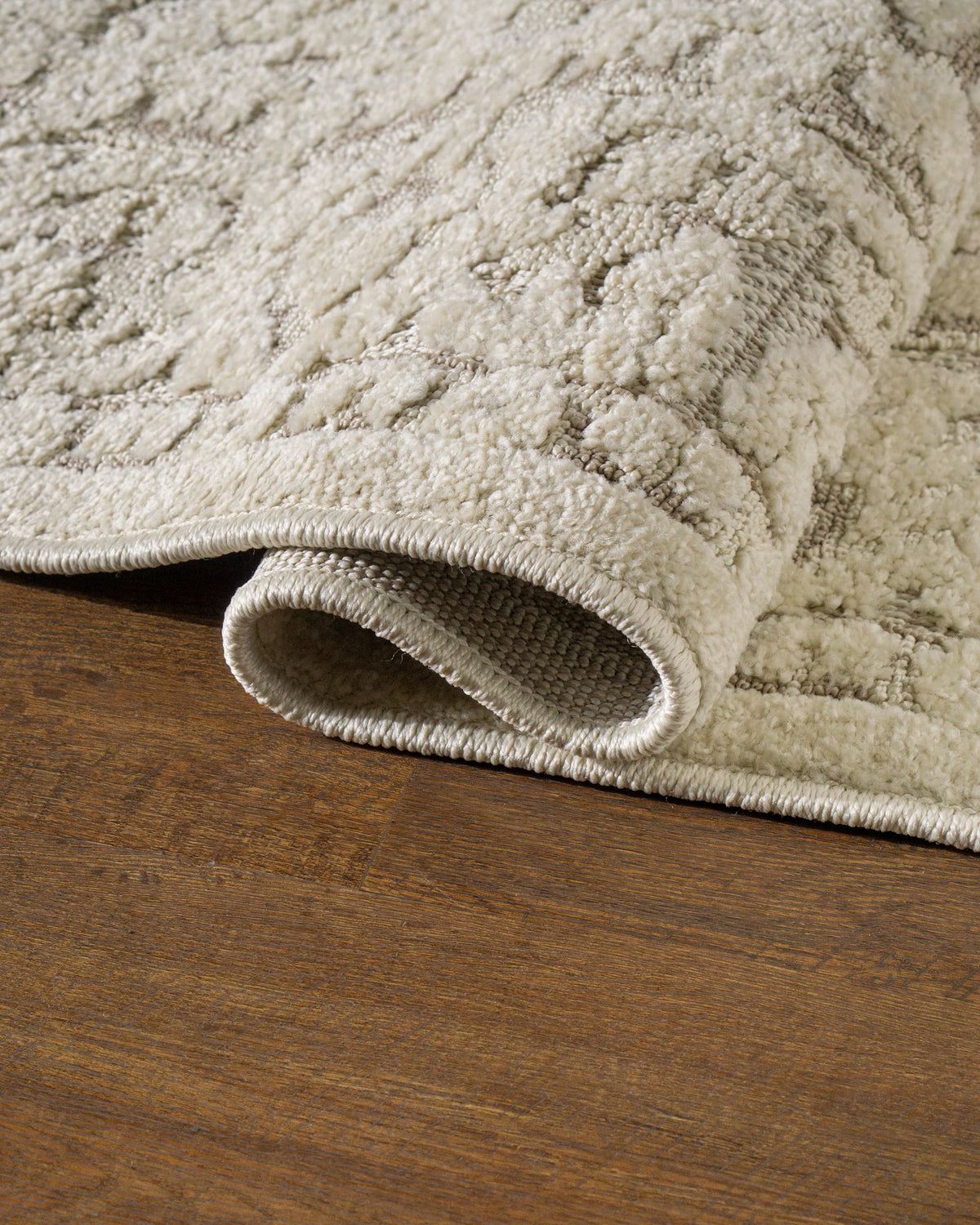 Cream and taupe traditional floral patterned area rug with ornate border