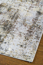 Abstract distressed rug with gold, grey, and cream weathered texture pattern