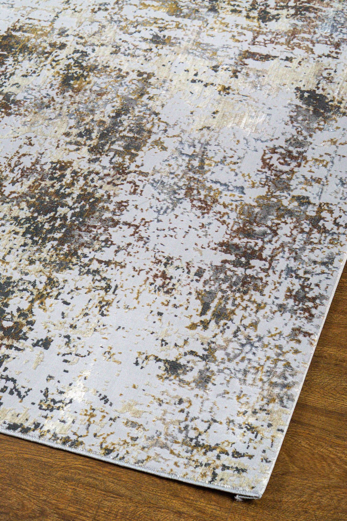Abstract distressed rug with gold, grey, and cream weathered texture pattern