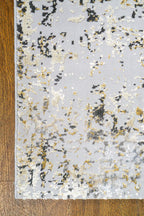 Abstract distressed rug with gold, grey, and cream weathered texture pattern
