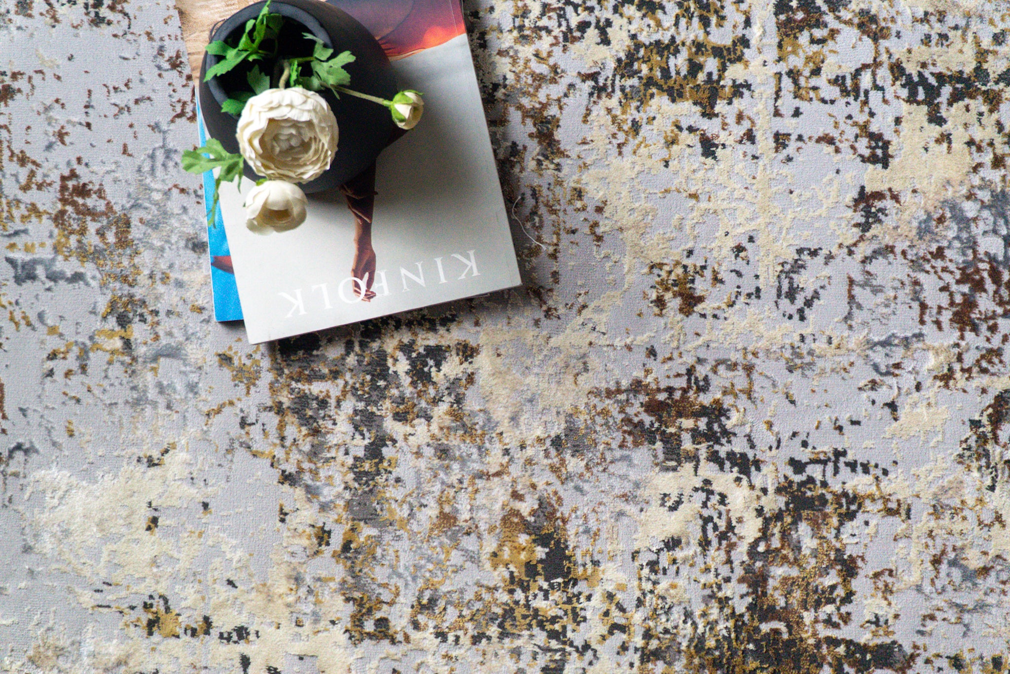 Abstract distressed rug with gold, grey, and cream weathered texture pattern