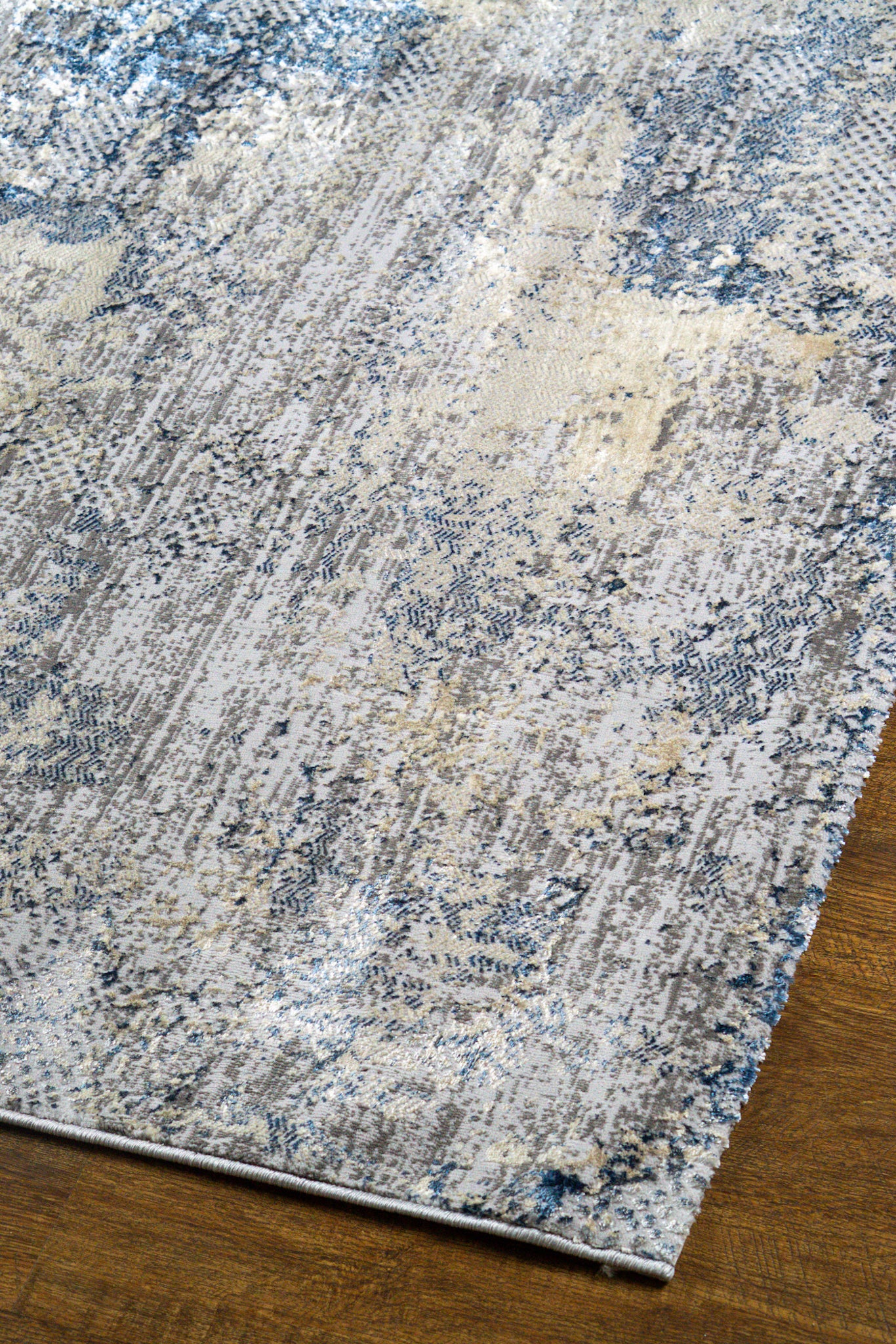 Modern distressed area rug with blue and grey abstract pattern on cream background