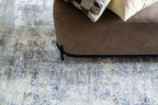 Modern distressed area rug with blue and grey abstract pattern on cream background