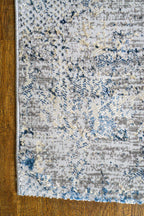 Modern distressed area rug with blue and grey abstract pattern on cream background