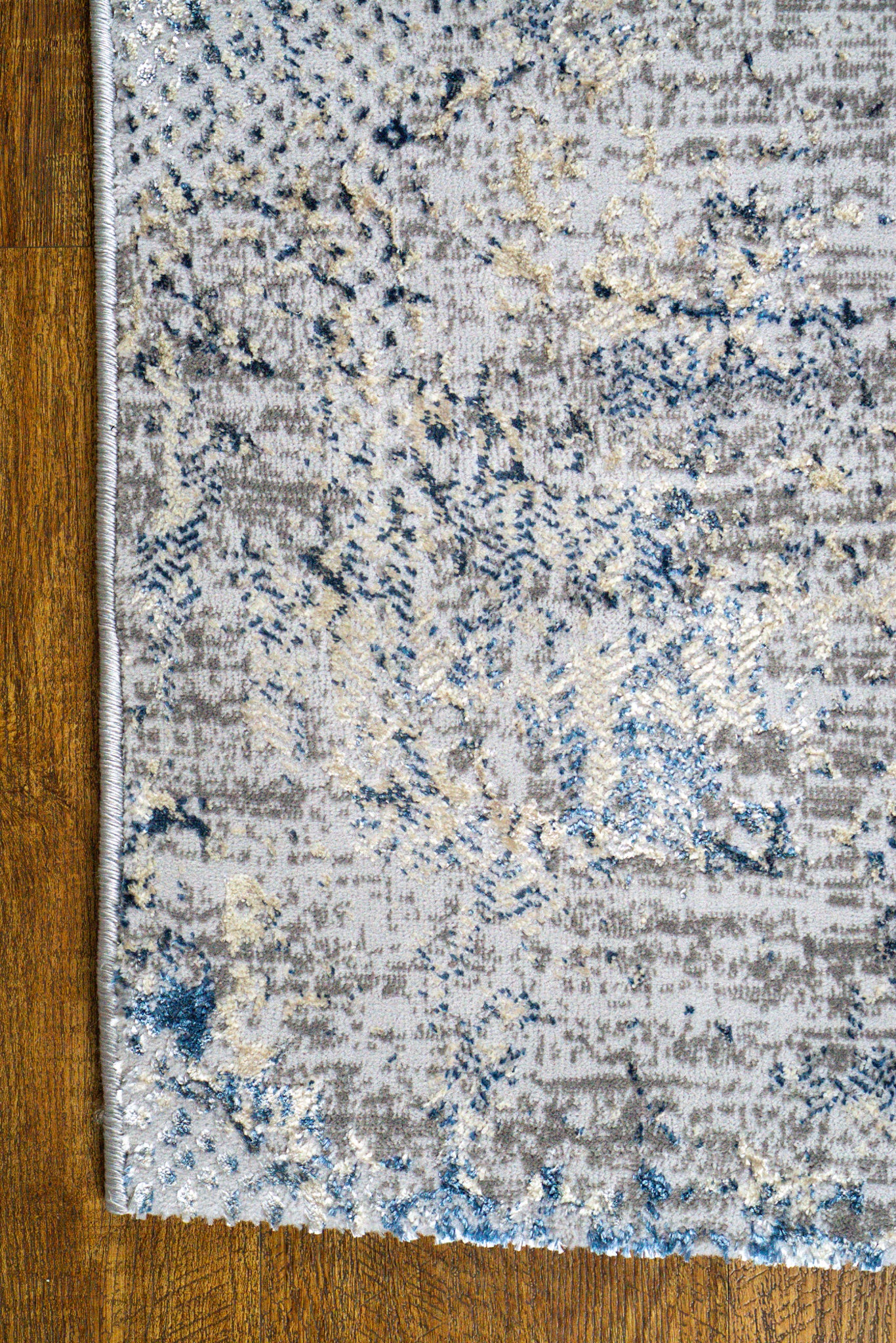 Modern distressed area rug with blue and grey abstract pattern on cream background