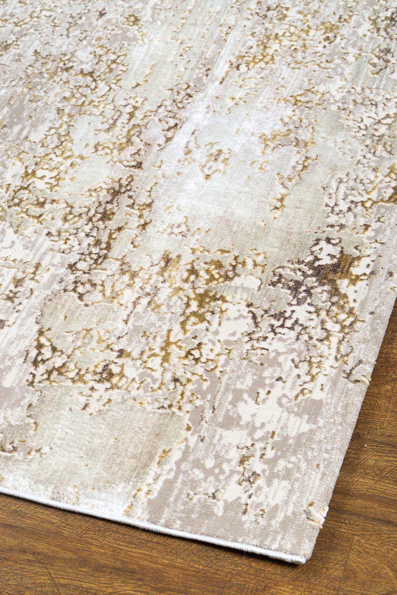 Distressed beige and gold abstract textured rug with worn vintage aesthetic
