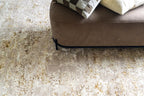 Distressed beige and gold abstract textured rug with worn vintage aesthetic