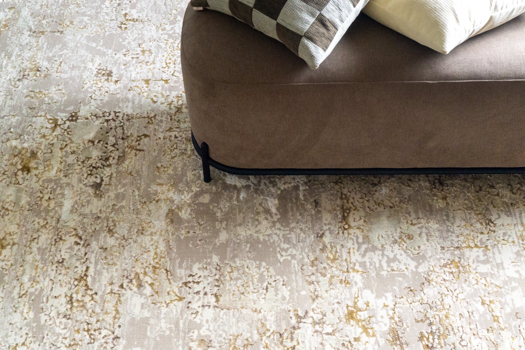 Distressed beige and gold abstract textured rug with worn vintage aesthetic