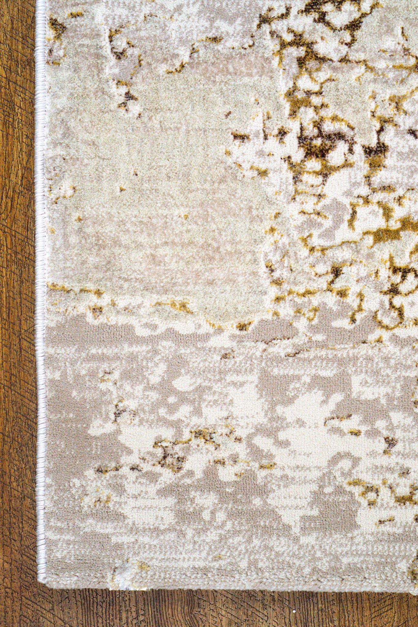 Distressed beige and gold abstract textured rug with worn vintage aesthetic