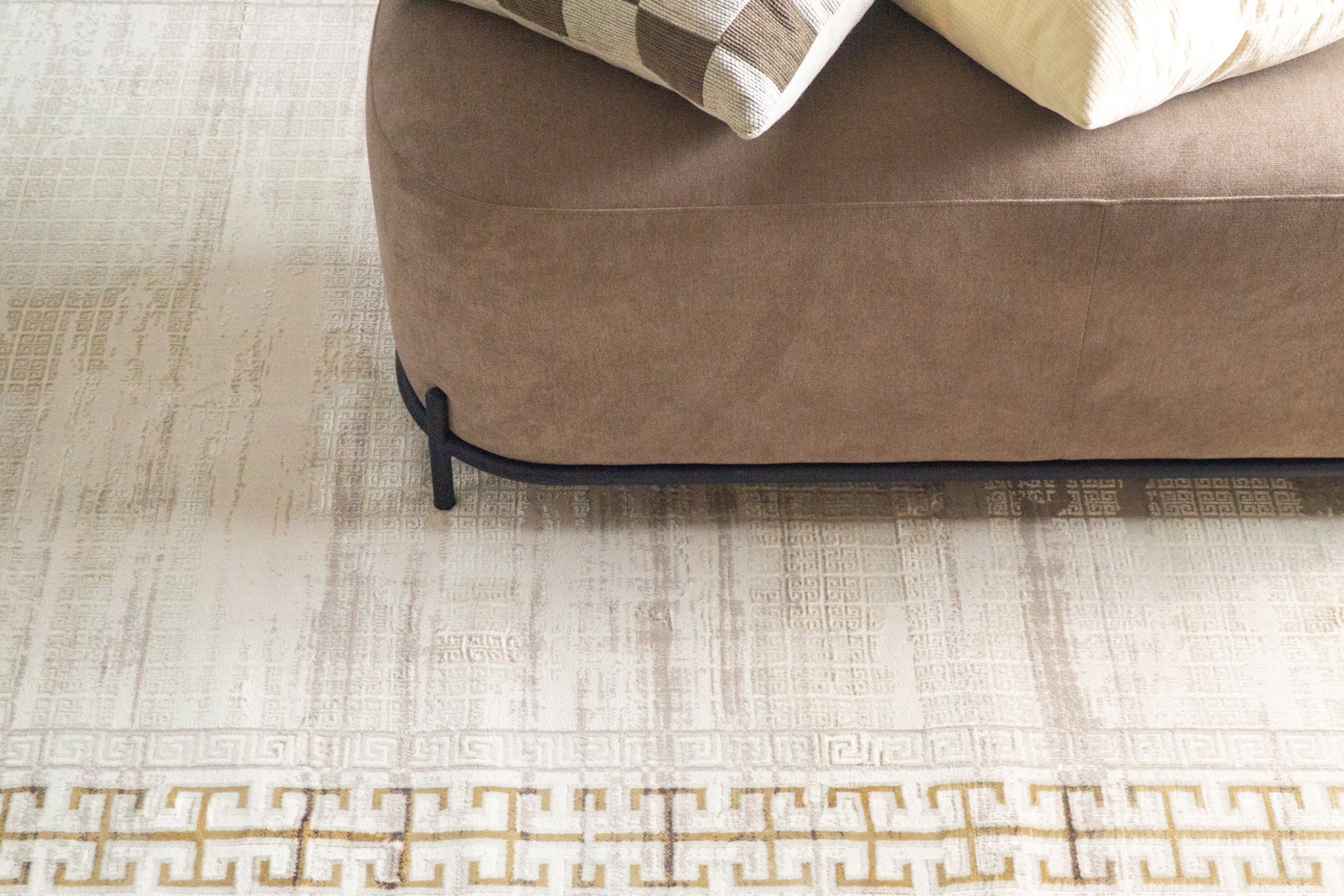 Cream and gold geometric Greek key patterned rug with textured distressed finish