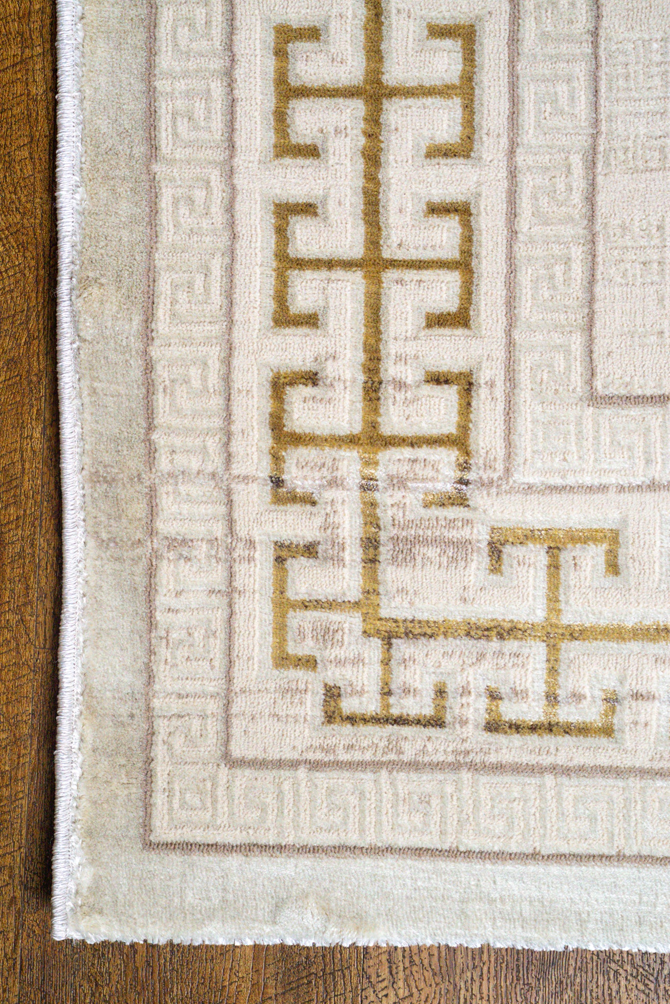 Cream and gold geometric Greek key patterned rug with textured distressed finish
