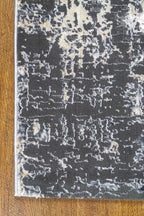 Modern distressed area rug in grey and cream tones with abstract pattern