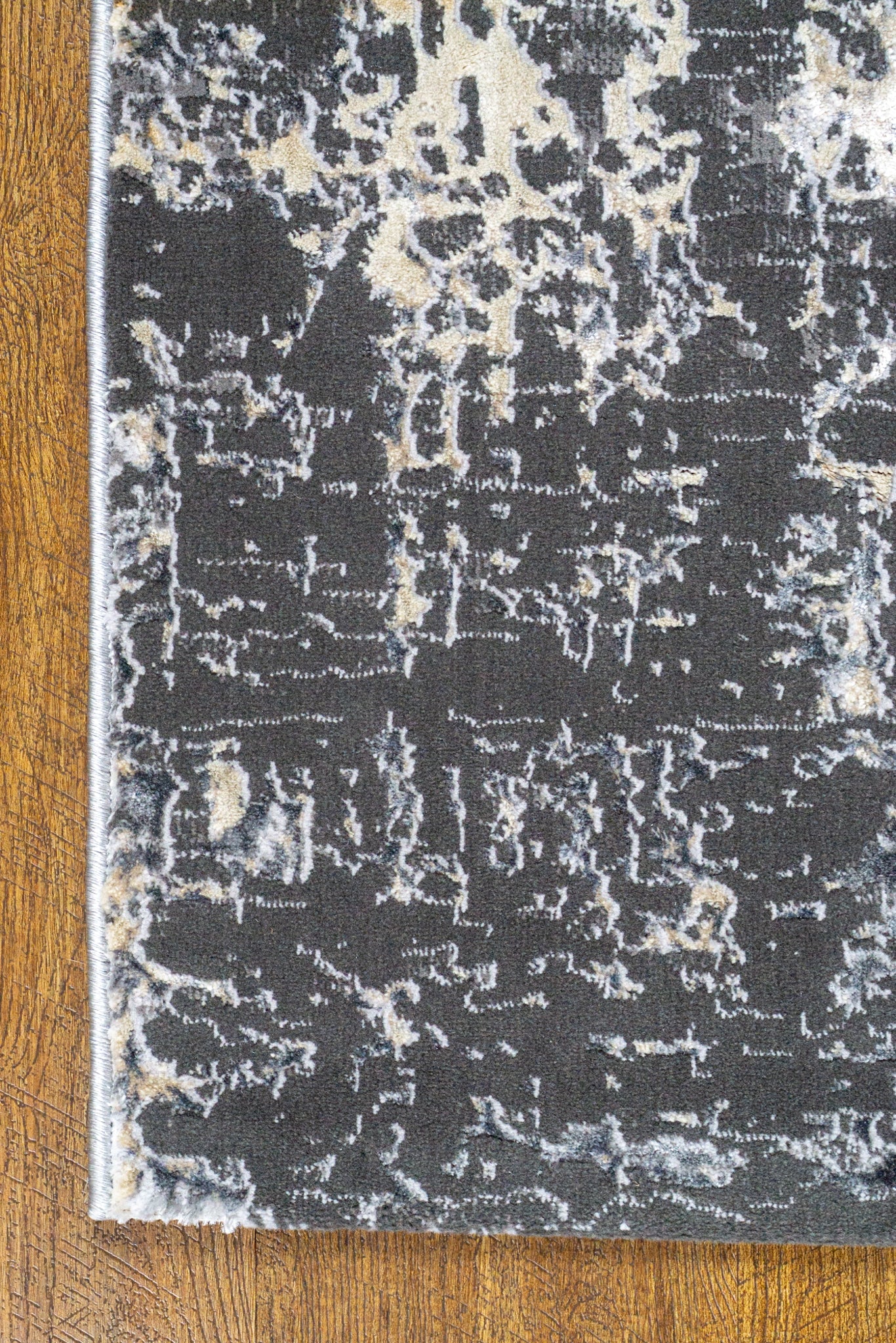 Modern distressed area rug in grey and cream tones with abstract pattern