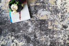Modern distressed area rug in grey and cream tones with abstract pattern