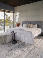 Modern distressed area rug with blue and grey abstract pattern on cream background
