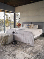 Modern distressed area rug in grey and cream tones with abstract pattern