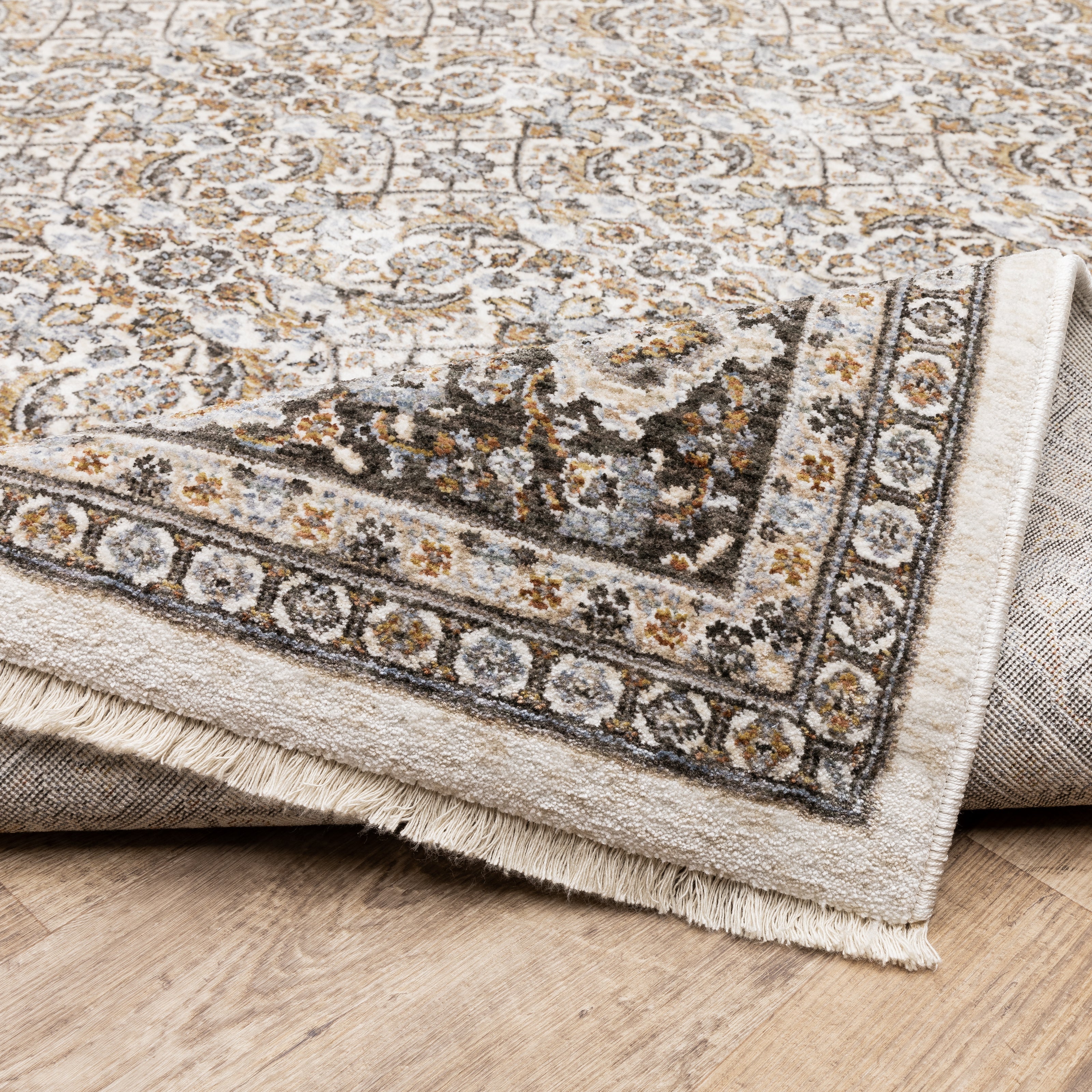 Traditional ornate rug with cream and brown geometric floral border pattern