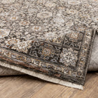 Vintage-style area rug with intricate geometric patterns in beige, taupe and cream tones