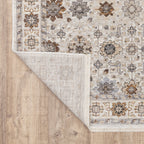 Beige traditional rug with brown and grey floral medallion pattern and ornate border