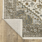 Traditional beige rug with blue and gold geometric medallion pattern and ornate borders