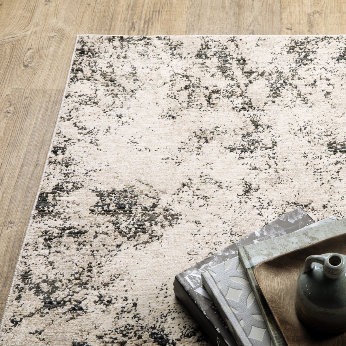 Modern distressed rug with black speckled pattern on cream background texture