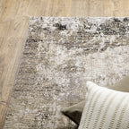 Modern living room with distressed gray and beige area rug under black coffee table
