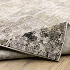 Modern living room with distressed gray and beige area rug under black coffee table