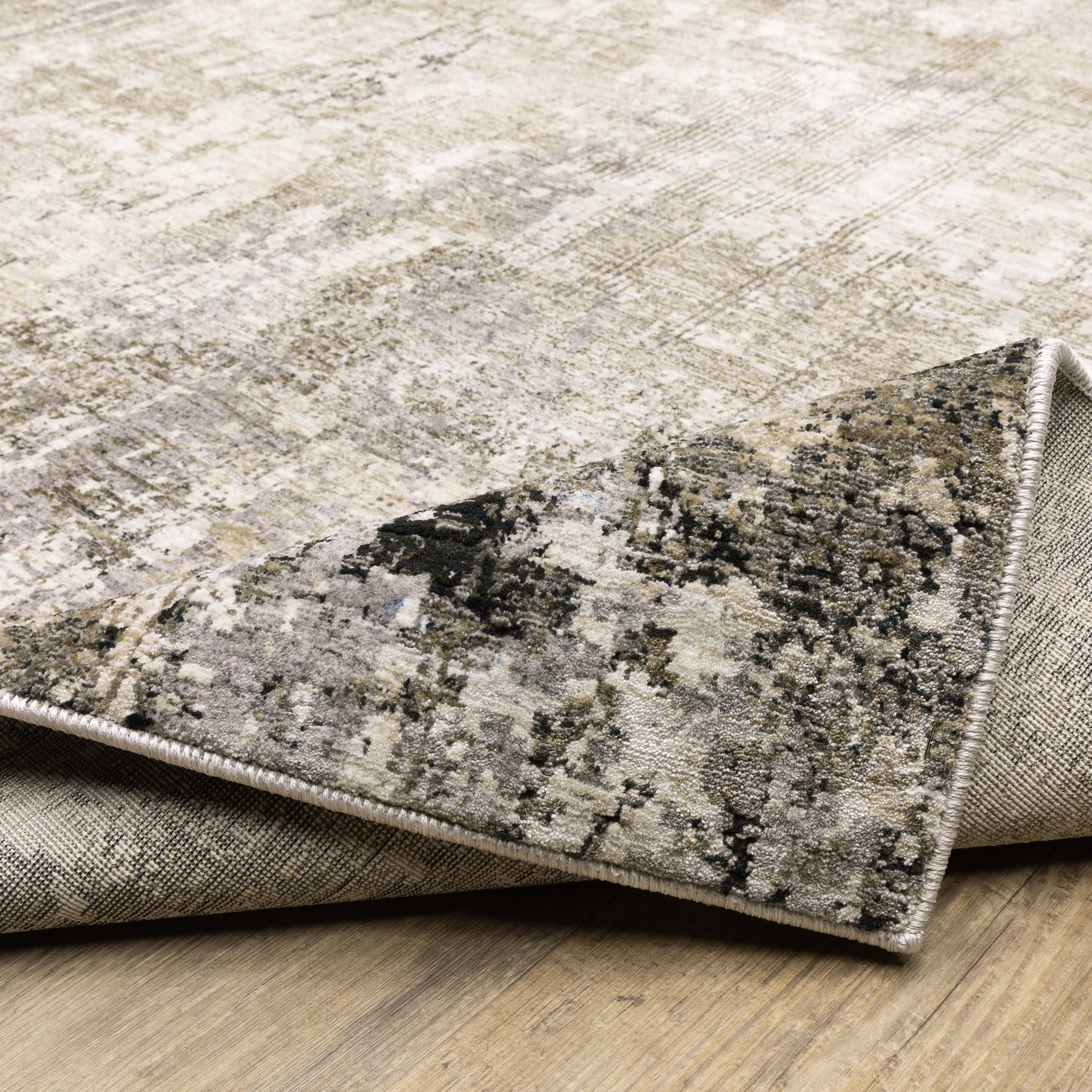Modern living room with distressed gray and beige area rug under black coffee table