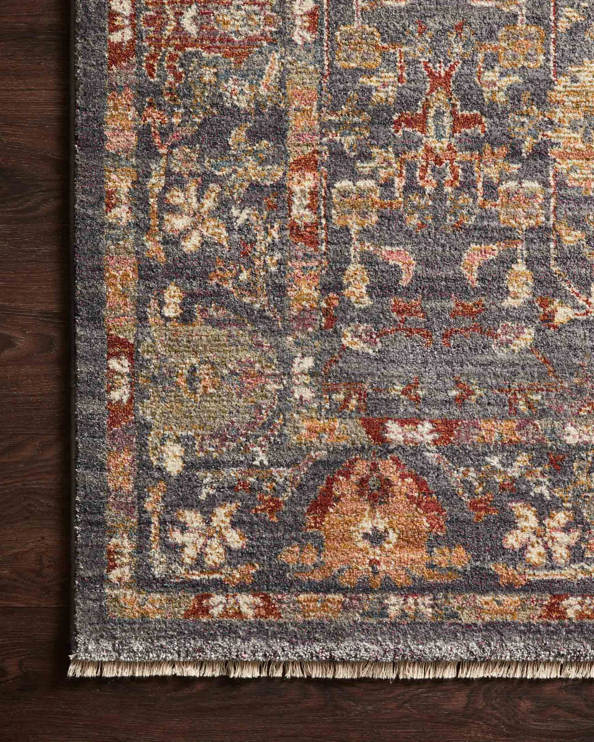 Vintage-style area rug with ornate floral medallions in blue, rust, and gold tones