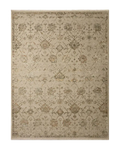 Beige and tan distressed floral pattern rug on dark wood flooring
