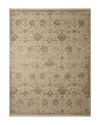 Beige and tan distressed floral pattern rug on dark wood flooring