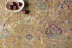 Vintage-inspired area rug with warm tan, blue, and purple tones in traditional pattern
