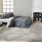 Grey textured rug with subtle horizontal striations and mottled appearance throughout