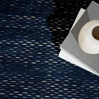 Dark blue textured area rug with subtle horizontal striations and woven pattern