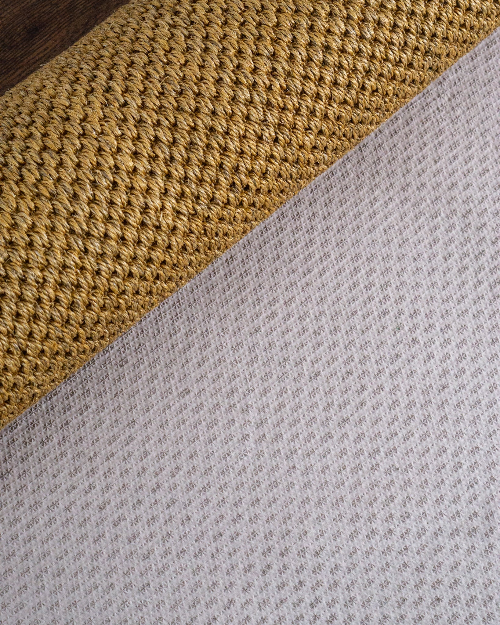 Natural woven jute rug with tight diagonal weave texture in tan and beige tones