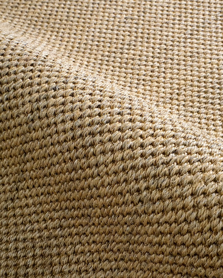 Beige woven sisal rug with diagonal ribbed texture pattern