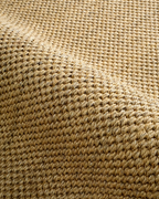 Natural woven jute rug with tight diagonal weave texture in tan and beige tones