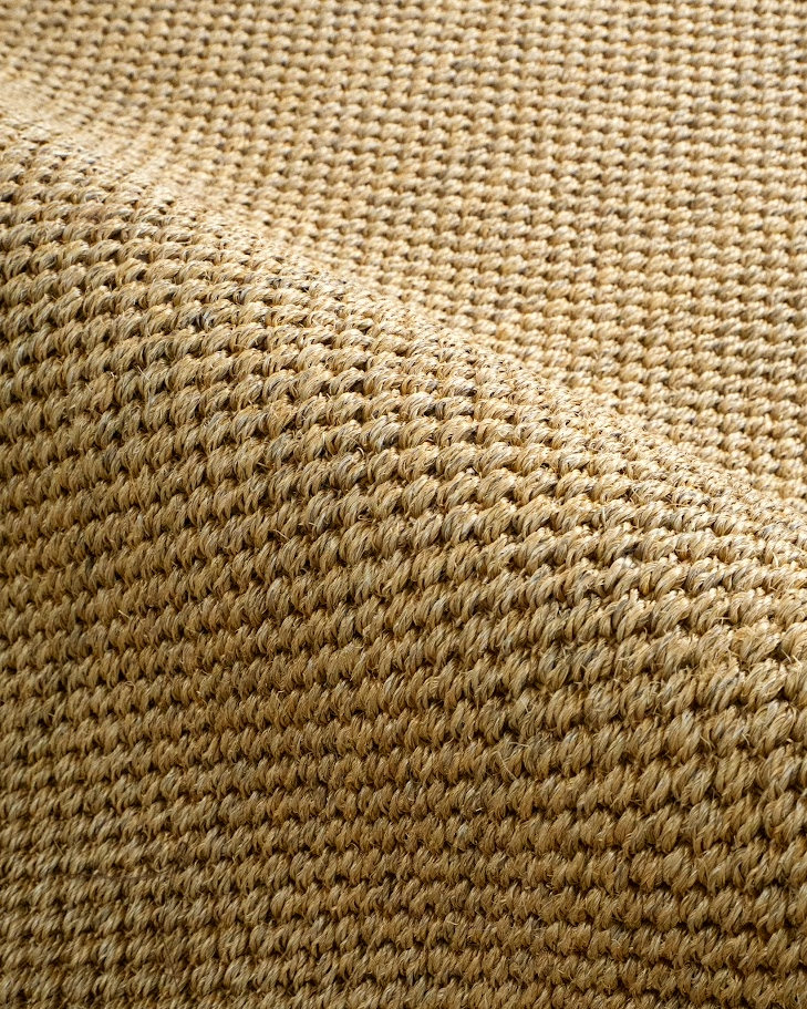 Natural woven jute rug with tight diagonal weave texture in tan and beige tones