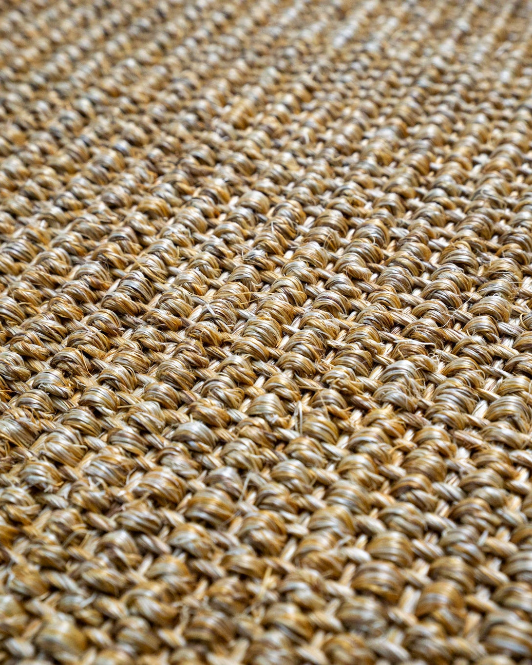 Natural woven jute rug with tight basket weave texture in tan and beige