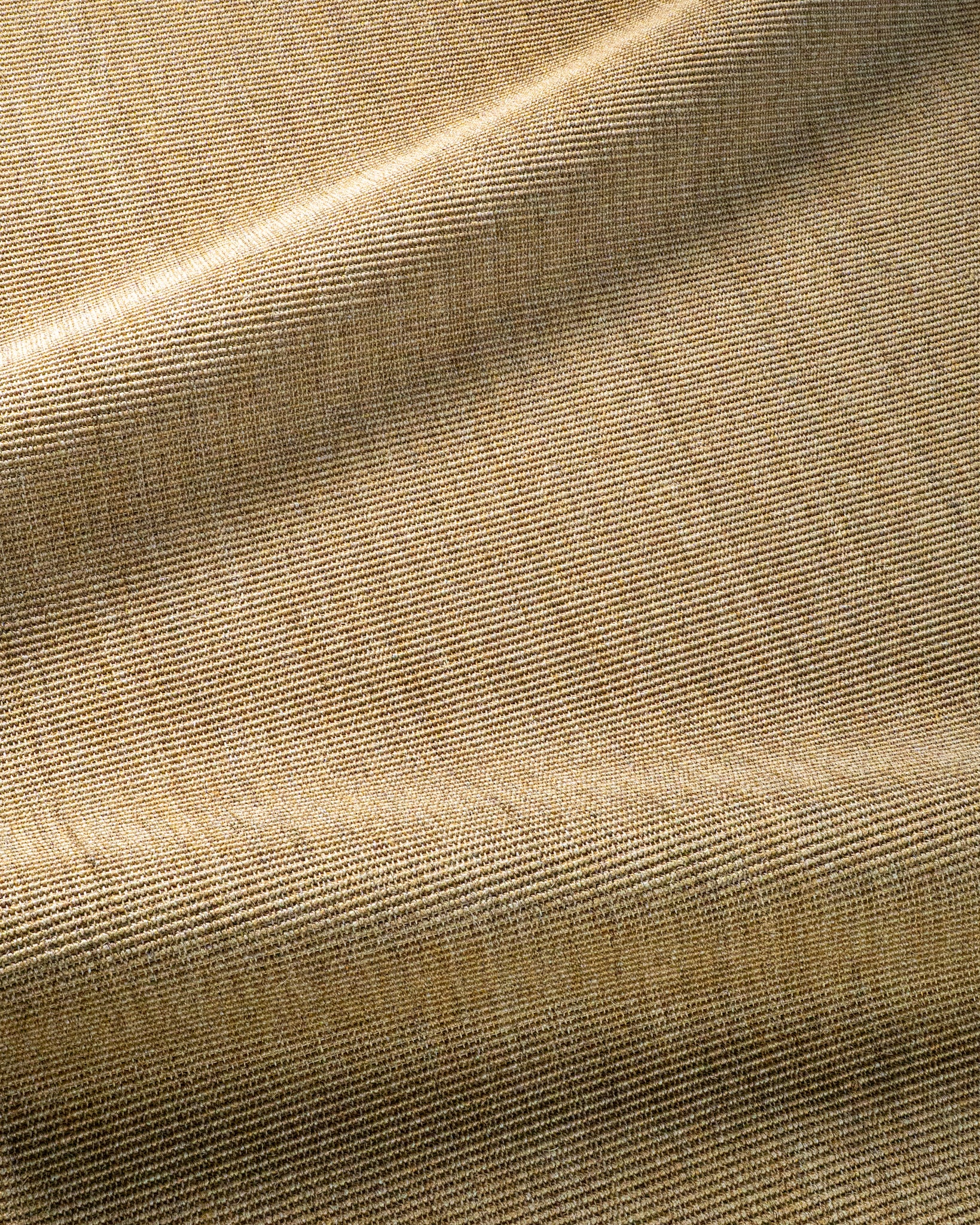 Natural woven jute rug with tight basket weave texture in tan and beige